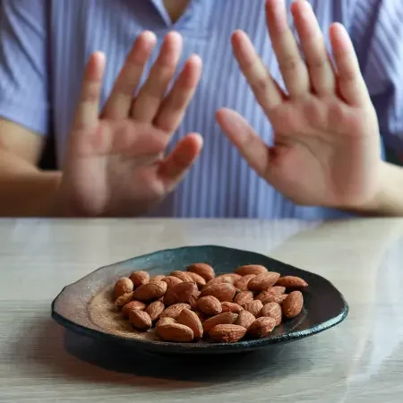 Person refusing almonds as part of managing tree nut allergies.