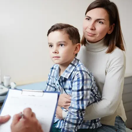 Mother with child consulting doctor on what to expect during an oral food challenge.